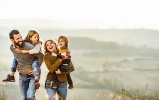 Young happy family enjoying in autumn walk on a hill.